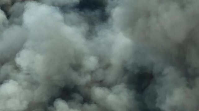 An aerial view of massive smoke plumes from an industrial fire, filling the atmosphere with toxic haze, symbolizing pollution, climate impact, and growing concerns over sustainable industry practices.
