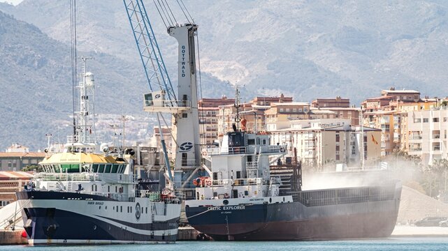 Malaga, Spain; March 29, 2026: The Ram&oacute;n Margalef, an oceanographic vessel belonging to the Spanish Institute of Oceanography, is docked in the port next to a cargo ship that is kicking up dust as it