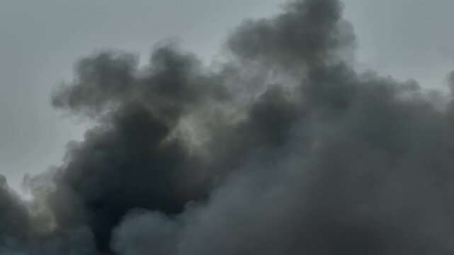 Black smoke plume expanding into the sky highlights global warming, emission levels, environmental impact, and the critical importance of ESG and sustainability efforts worldwide. Thailand. 4k.
