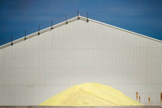 Yellow sulfur pile in industrial building storage facility