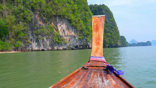 Peaceful boat ride in a tropical limestone bay, showcasing sustainable tourism, environmental balance, biodiversity protection, and responsible travel in a warming world.  Thailand. 4k.
