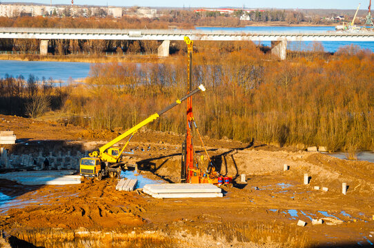 Construction site working, truck crane and pile driver slabs during industrial works at the construction site, view from height