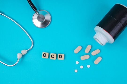 Top View Of OCD Word In Tiles With Stethoscope And Spilled Pills For Medical Treatment Concept