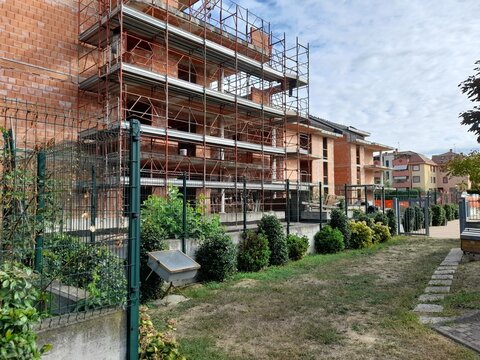 Lavori in corso nel cantiere edile in primavera - gru e ponteggio