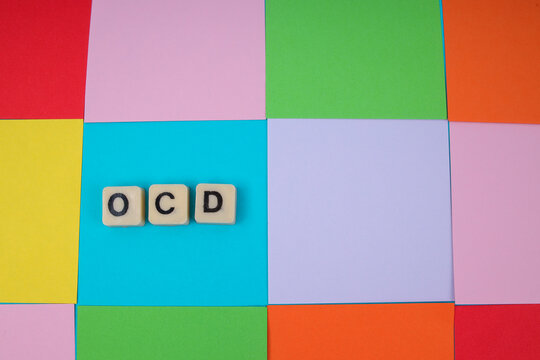 Top View Of OCD Word In Tiles On Colorful Square Grid For Mental Health Concept