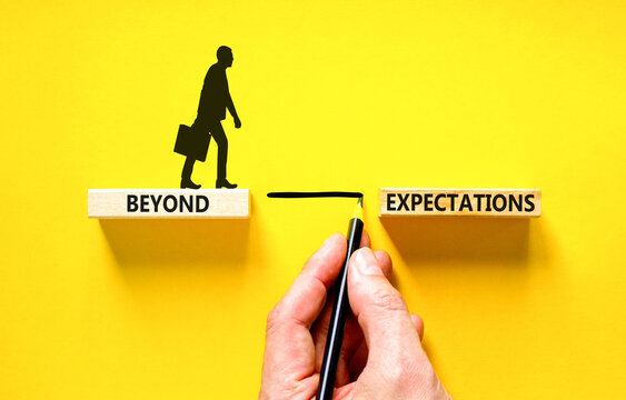 Beyond expectations words symbol. Concept words Beyond expectations on beautiful wooden blocks. Beautiful yellow background. Businessman hand. Business Beyond expectations words concept. Copy space.