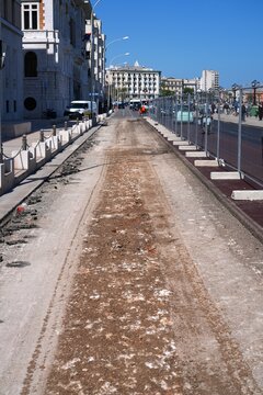 Road construction resurfacing works, pavement milling and replacement in Lungomare Nazario Saurio street in Bari, Italy. Fenced off construction site.