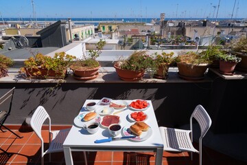 Obraz premium Italian breakfast on a rooftop terrace. Outdoor table with Italian food in Molfetta, Italy.