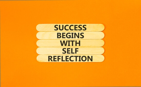 Self reflection symbol. Concept words Success begins with self reflection on beautiful wooden sticks. Beautiful orange background. Business success begins with self reflection concept. Copy space.