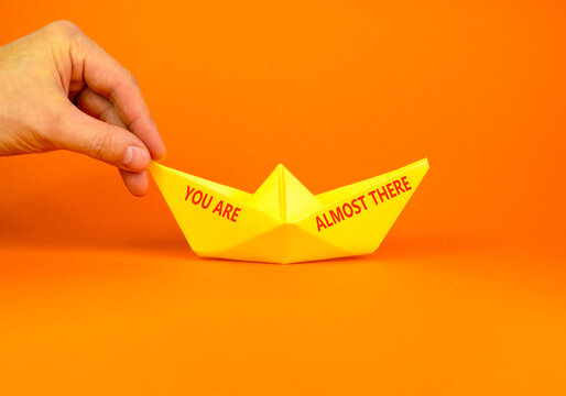 You are almost there words symbol. Concept words You are almost there on beautiful paper boat. Beautiful orange background. Business You are almost there motivational support concept. Copy space.