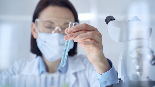 Scientist female researcher with protective glasses and mask exa