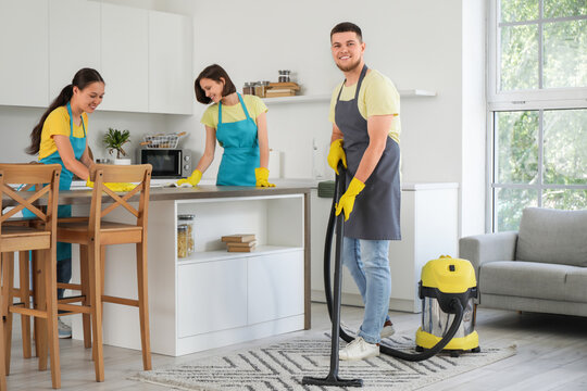 Group of young janitors cleaning in kitchen