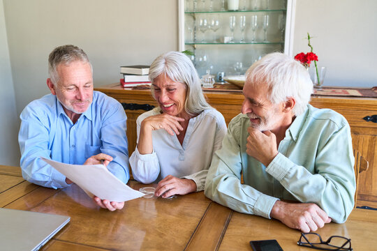 Retirement Planning And Financial Security: Senior Couple Reviewing Documents With Advisor For Long-Term Investment