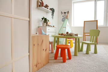 Interior of light playroom with toys, teepee and whiteboard in kindergarten © Pixel-Shot