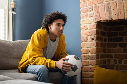 Teenage football fan watching a match on TV
