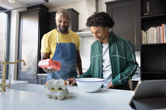 Father teaching teenage son to cook