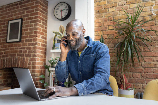 Man on Phone with Laptop working from home