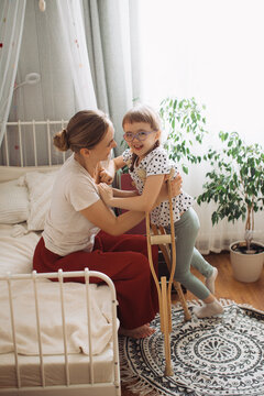 Mother supporting happy child with physical disability at home