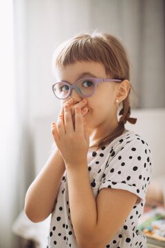 Little girl with vision impairment covering mouth
