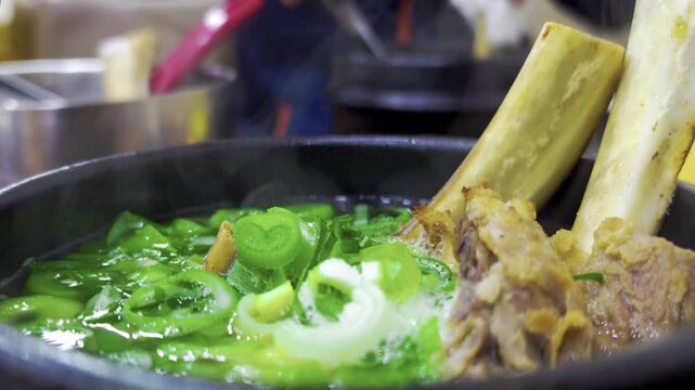 Galbitang or Korean Beef Short Rib Soup bubbling and served on a table