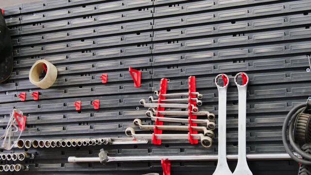 Mechanic wrenches kit adhesive tape and goggles on rack in workplace closeup. Instruments and equipment to maintain cars at service station
