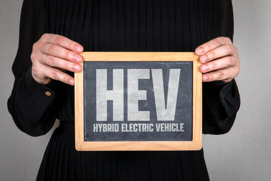 HEV Hybrid Electric Vehicle Text on Chalkboard Held by Person Concept