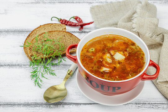 Meat solyanka soup with sausages, olives and vegetables served on table. Traditional bowl
