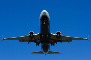Airplane flying overhead against clear blue sky   Samolot lecący tuż nad głową na tle czystego, błękitnego nieba © Adrian White