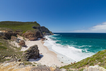 Fototapeta premium The amazing view on Diaz Beach at Cape Point, seen from the higher cliffs. The beach is a secluded and magnificent stretch of amazing white sand, turquoise waters and surrounded with 200meter high cli