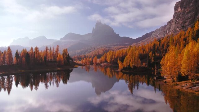Rising above Lago Federa lake in Dolomites, Italy surrounded by golden larch forest