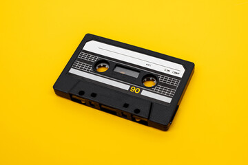 Fototapeta premium Black audio cassette on yellow background