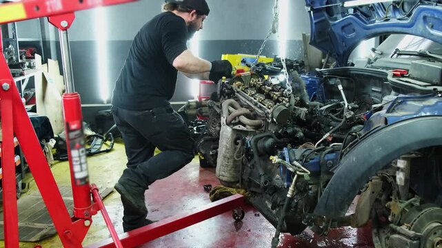 Technician works on restoring major part of automobile. Mechanic performs visual analysis of engine touching surface of mechanism with hands