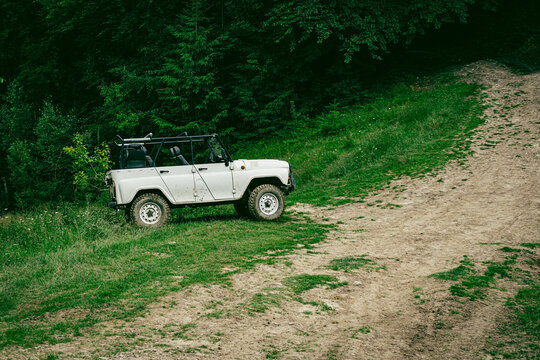 White offroad vehicle in green forest