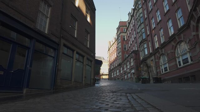 Ultra-low cinematic slide along the cobblestones of Side in Newcastle, showcasing the historic architecture and steep incline under soft early morning light.