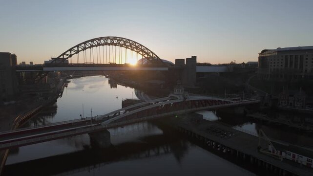 Pan from interior of High Level Bridge to sun rising behind Tyne Bridge on a beautiful morning in Newcastle. Swing and Millennium bridges are also seen 
