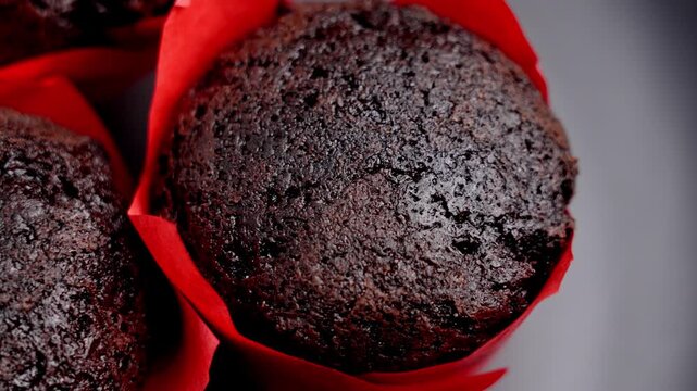 Gluten free chocolate cupcakes in a red liner on a black background. Sweet dietary treats. Homebaked confectionery concept