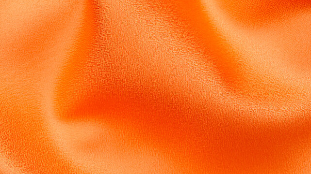 Bright orange fabric draped with folds showing smooth texture and shine in natural light
