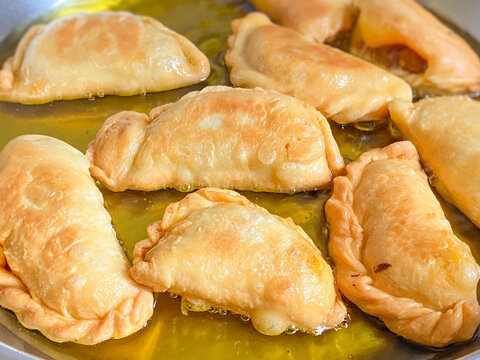 Freshly fried Malaysian karipap curry puff with crispy golden pastry texture.