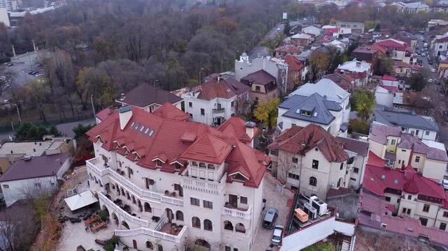Aerial drone view of Suter Palace in Bucharest, a grand early 20th-century white mansion with terracotta roofs, arched arcades, and terraces near Carol Park.