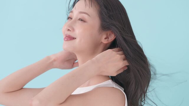 女性　ブルーバック　髪　風