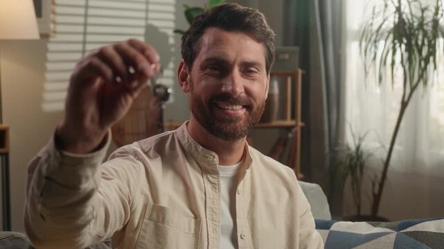 Smiling Caucasian buyer client adult man holding bunch of keys in living room in luxury new home male smile with key buying property moving day relocation house bank invest mortgage achive ownership