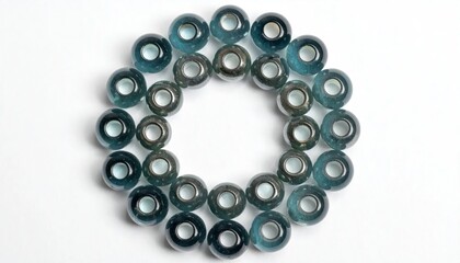 Fototapeta premium Round teal and dark blue glass beads arranged in a circular pattern on a white background