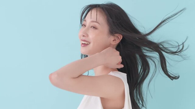 女性　ブルーバック　髪　風