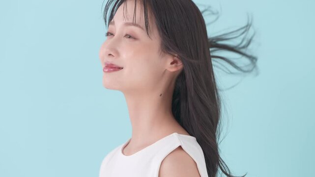 女性　ブルーバック　髪　風