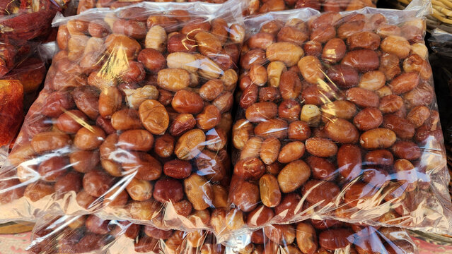 Packaged dried oleaster fruits (iğde) displayed in a clear bag, showing their wrinkled golden-brown texture. A traditional Anatolian dried fruit known for its distinctive sweet-sour flavor and natural