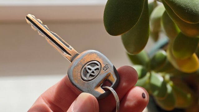Sosnoviy Bor, Russia - April 28, 2026: Hand holding a silver car key old toyota ignition key