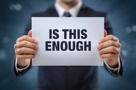 Is This Enough is the Question on a Sign Held by a Businessman