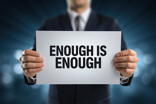 Businessman Holding a Sign with the Firm Statement Enough is Enough