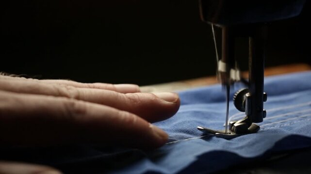 Seamstress working on a vintage sewing machine, retro style sewing machine in operation