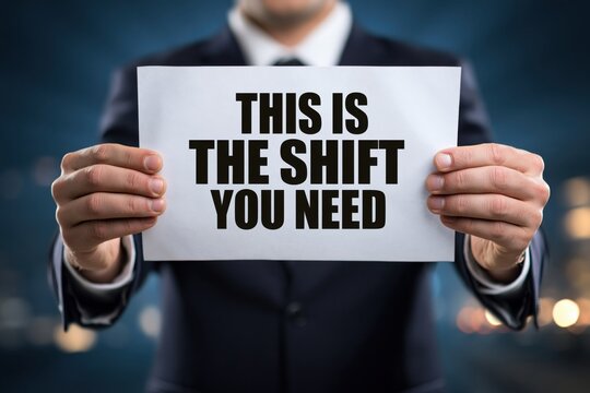Businessman with a Sign Stating 'This is The Shift You Need'